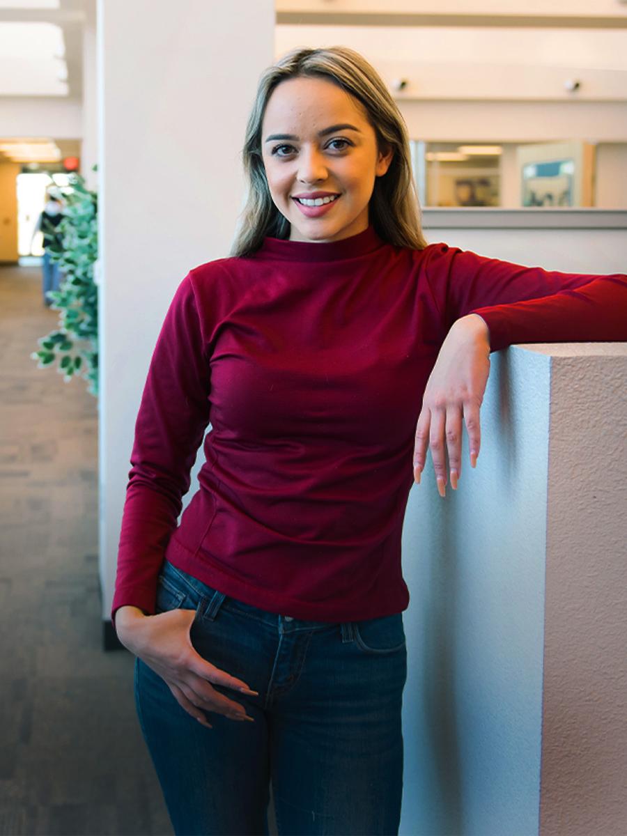 A student stands in a student lounge at a Pima Campus